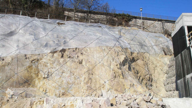 Messa in sicurezza delle pareti rocciose a monte dell'area di cantiere tramite rete metallica e rinforzi di funi d'acciaio. Zona residenziale "Huberweide", Renon (BZ), 2019.