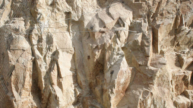 Absicherung der Felsböschungen bergseitig der Baustellenfläche mittels Metallgitternetzen verstärkt mit Stahlseilen und Verankerungen mittels Felsnägel. Völser Aicha (BZ), 2017.